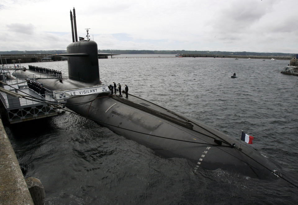 FILE - In this July 13, 2007 file photo, French Marine officers wait atop "Le Vigilant" nuclear submarine at L'Ile Longue military base, near Brest, Brittany. Stealthily cruising the ocean deeps, deliberately hiding from the world now in turmoil, the crews of nuclear-armed submarines may be among the last pockets of people anywhere who are still blissfully unaware of how the coronavirus pandemic is turning life upside down. The new coronavirus causes mild or moderate symptoms for most people, but for some, especially older adults and people with existing health problems, it can cause more severe illness or death. (AP Photo/Francois Mori, Pool, File)
