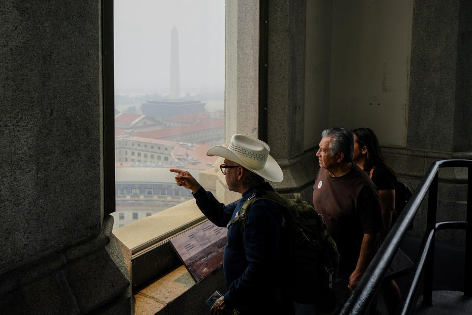 People tour the top of the Old Post Office Tower as haze from a blanket of smoke covers the view, Thursday, June 8, 2023, in Washington. Canadian wildfires are blanketing the northeastern U.S. in a haze, turning the air acrid, the sky yellowish gray and prompting warnings for vulnerable populations to stay inside. (AP Photo/Julio Cortez)