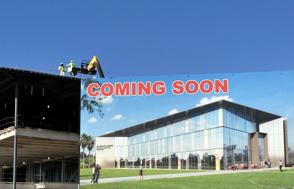 Construction workers labor behind a sign facing Clyde Morris Boulevard in Daytona Beach depicting the Hyatt and Cici Brown Center for Aerospace Technology, which will be a 45,000 square-foot Sensitive Compartmented Information Facility, or SCIF, at Embry-Riddle Aeronautical University's research park. In the 2023-2024 state budget, the university received $15 million for construction and $5 million for equipment there, while $26 million was included in this year's budget for yet another research building.