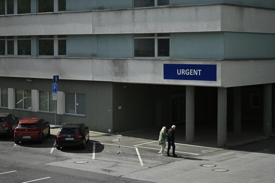 A couple walk towards a building at the F. D. Roosevelt University Hospital, where Slovak Prime Minister Robert Fico, who was shot and injured, is being treated, in Banska Bystrica, central Slovakia, Saturday, May 18, 2024. The man accused of attempting to assassinate Slovak Prime Minister Robert Fico made his first court appearance Saturday as the nation's leader remained in serious condition recovering from surgery after surviving multiple gunshots, Slovak state media said. (AP Photo/Denes Erdos)