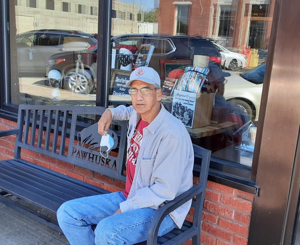 Harrison Shackelford, a member of the Osage Nation who lives in Pawhuska, sits on a bench across the street from the Ben Johnson Cowboy Museum, in downtown Pawhuska on April 24, 2021.