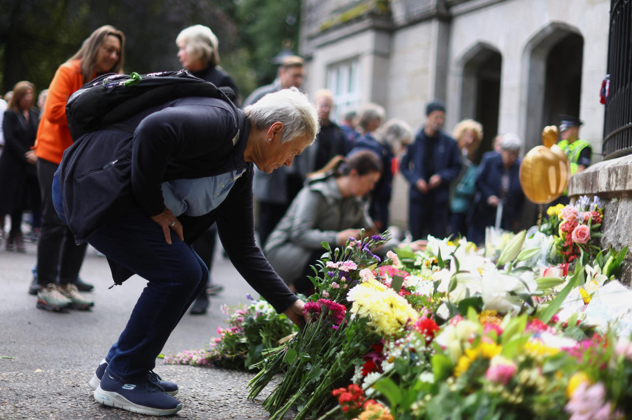 People lay flowers outside the gate of Balmoral Castle, following the passing of Britain's Queen Elizabeth, in Balmoral, Scotland, Britain, September 9, 2022. REUTERS/Hannah McKay