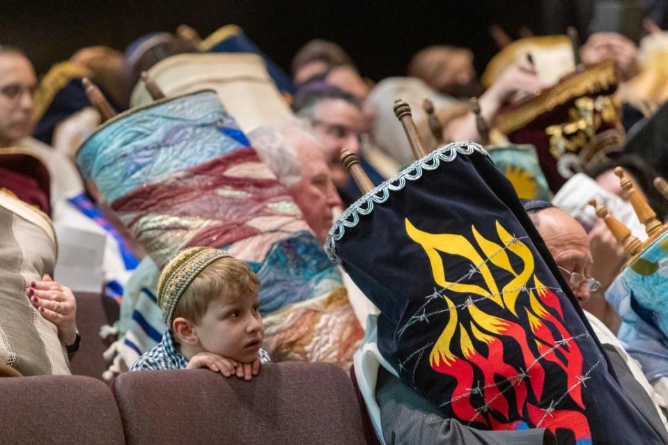 Jacob Pressman, 4, sits Sunday among dozens of torahs saved from the Holocaust. N.Y.Post/Chad Rachman