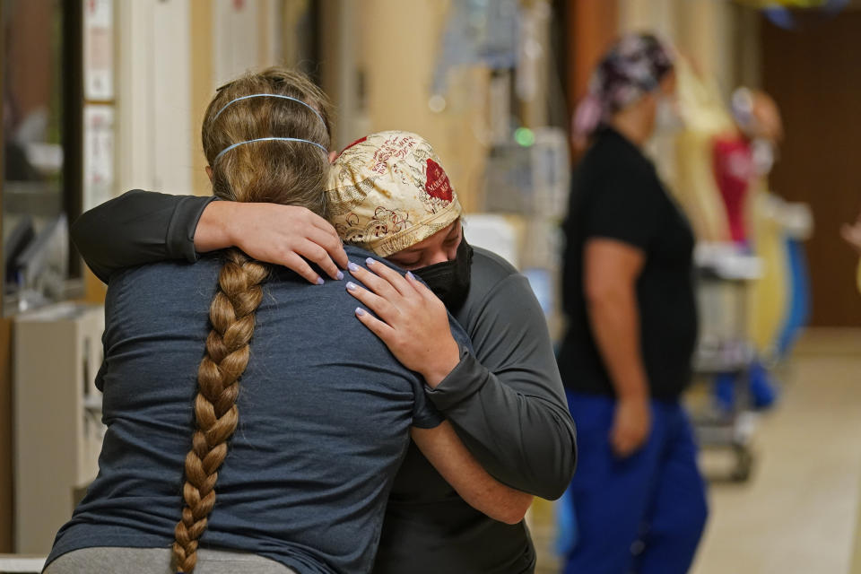 ICU nurse Melinda Hunt, facing, hugs the sister of a COVID-19 patient she had been caring for, who had just passed away, inside a COVID unit at the Willis-Knighton Medical Center in Shreveport, La., Wednesday, Aug. 18, 2021. (AP Photo/Gerald Herbert)