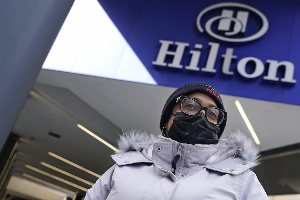Hotel housekeeper Esther Montanez poses outside the Hilton Back Bay, Friday, March 5, 2021, in Boston. Montanez refuses to give up hope of returning to her cleaning job at the hotel, which she held for six years until being furloughed since March 2020 due to the COVID-19 virus outbreak. (AP Photo/Charles Krupa)