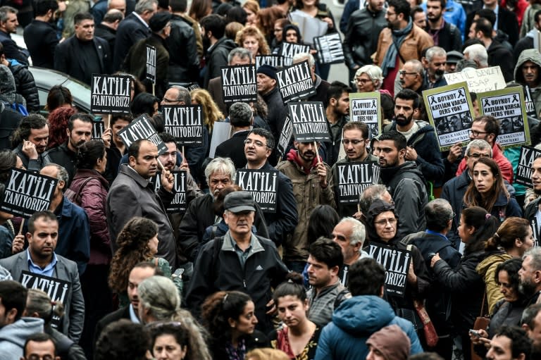 Protesters hold placards that read "We know the killer" as Turkish riot police block the road on October 13, 2015 in Istanbul during a demonstration against the deadly attacks in Ankara