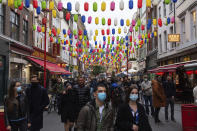 People out in Chinatown, on the first day after the city was put into Tier 2 restrictions to curb the spread of coronavirus, in London, Saturday, Oct. 17, 2020. Prime Minister Boris Johnson this week introduced a three-tier regional approach to combating the coronavirus pandemic, with each tier bringing in progressively tighter restrictions. The government is trying to slow rising infection rates and prevent the National Health Service from being swamped with COVID-19 cases this winter while seeking to avoid a national lockdown that would ravage the U.K.‘s struggling economy. (Dominic Lipinski/PA via AP)