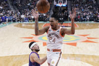 San Antonio Spurs guard Devin Vassell (24) scores over Phoenix Suns guard Devin Booker (1) during the first half of an NBA basketball game in San Antonio, Monday, March 25, 2024. (AP Photo/Eric Gay)