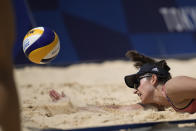 Sarah Sponcil, of the United States, dives for the ball during a women's beach volleyball match against Canada at the 2020 Summer Olympics, Sunday, Aug. 1, 2021, in Tokyo, Japan. (AP Photo/Felipe Dana)