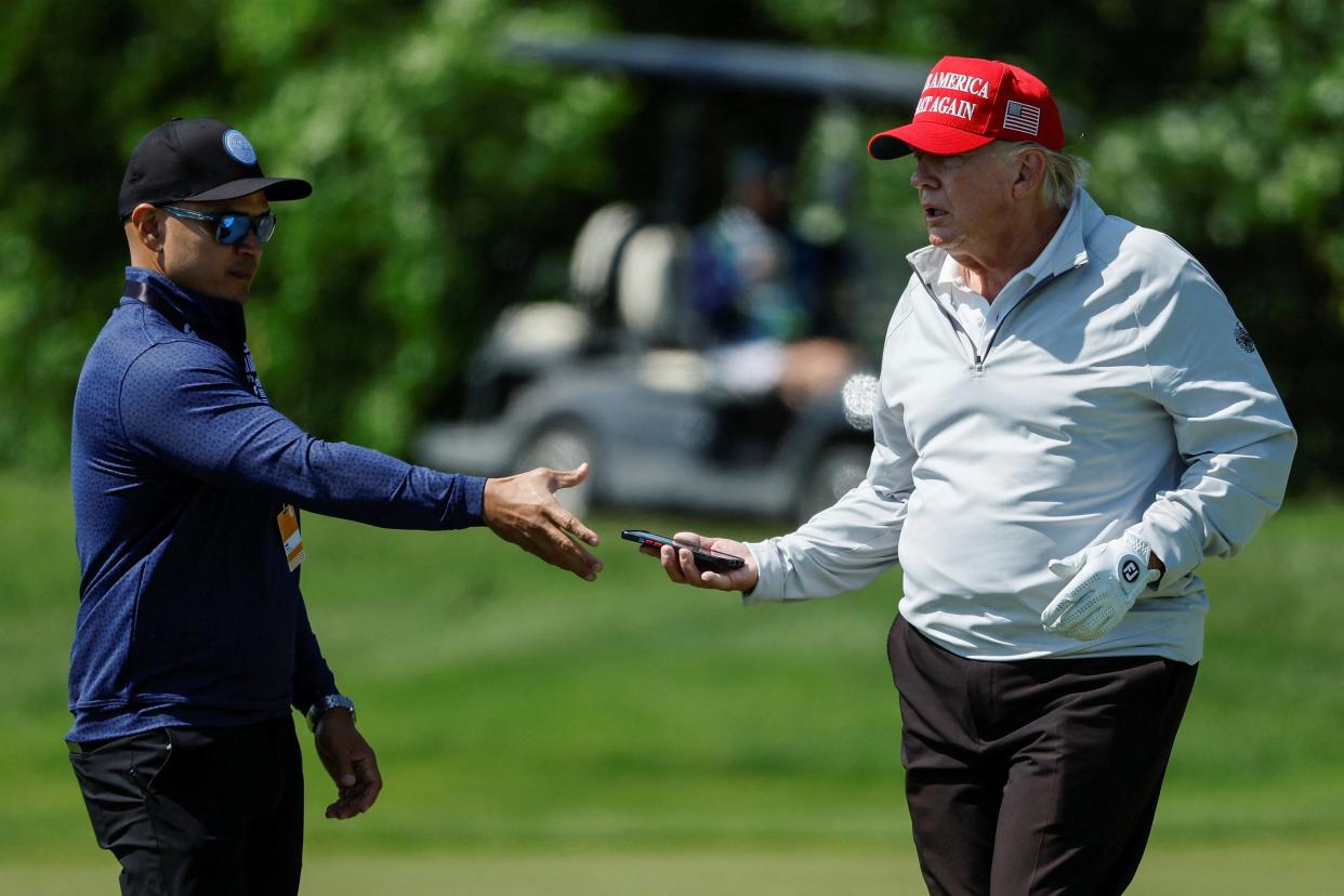 Walt Nauta, personal aide to former US President Trump, walks with him at the Trump National Golf Club in Sterling, Virginia (Reuters)