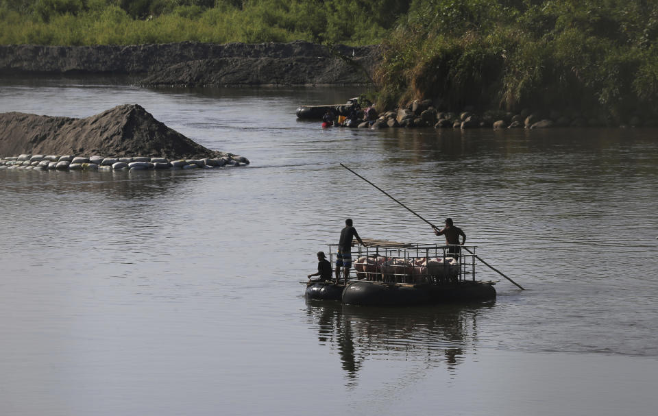 Men transport pigs across the Suchiate River, from Mexico to Guatemala, as they move away from Ciudad Hidalgo, Mexico, Friday, Jan. 24, 2020, a location popular for migrants to cross from Guatemala to Mexico. (AP Photo/Marco Ugarte)