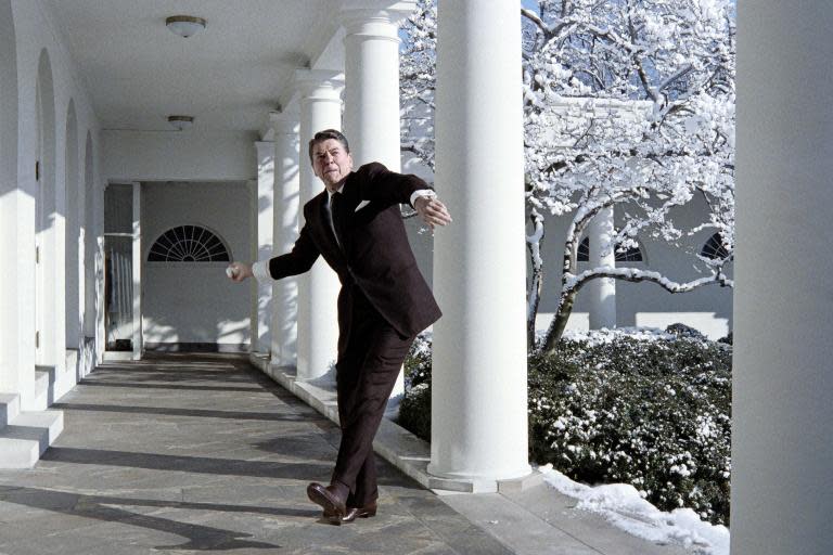 Late US president Ronald Reagan throws a snowball at the media while on his way February 25, 1986 to the Oval Office at the White House, Washington, D.C