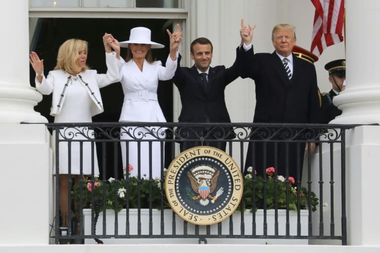 French President Emmanuel Macron, US President Donald Trump, US First Lady Melania Trump and Brigitte Macron salute the crowd from the balcony during a state welcome at the White House