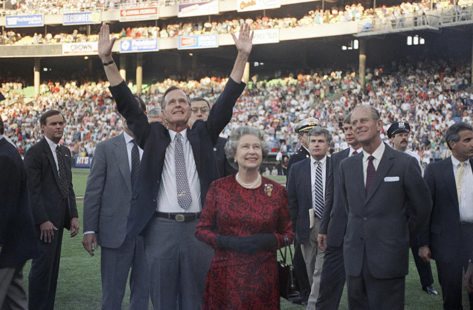 FILE - President George H. W. Bush escorts Queen Elizabeth II and Prince Philip on the field at Memorial Stadium on May 15, 1991, in Baltimore, before the Orioles played the Oakland A's. The FBI has disclosed a potential threat to the late Queen Elizabeth during her 1983 trip to the U.S. West Coast. The documents were released this last week of May, 2023, on the FBI’s records website. (AP Photo/Greg Gibson, File)