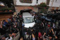 Un vehículo de una empresa funeraria es rodeado por fotógrafos y reporteros cuando llega a la casa del laureado escritor colombiano Gabriel García Márquez en Ciudad de México, el jueves 17 de abril de 2014. García Márquez falleció el jueves en su residencia. (AP Photo/Marco Ugarte)