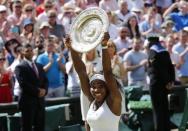 Serena Williams of the U.S.A lifts the trophy after winning her Women's Final match against Garbine Muguruza of Spain at the Wimbledon Tennis Championships in London, July 11, 2015. REUTERS/Suzanne Plunkett -