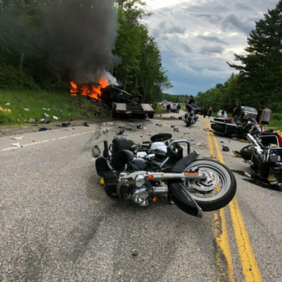 This photo provided by Miranda Thompson shows the scene where several motorcycles and a pickup truck collided on a rural, two-lane highway Friday, June 21, 2019 in Randolph, N.H. New Hampshire State Police said a 2016 Dodge 2500 pickup truck collided with the riders on U.S. 2 Friday evening. The cause of the deadly collision is not yet known. The pickup truck was on fire when emergency crews arrived. (Miranda Thompson via AP)