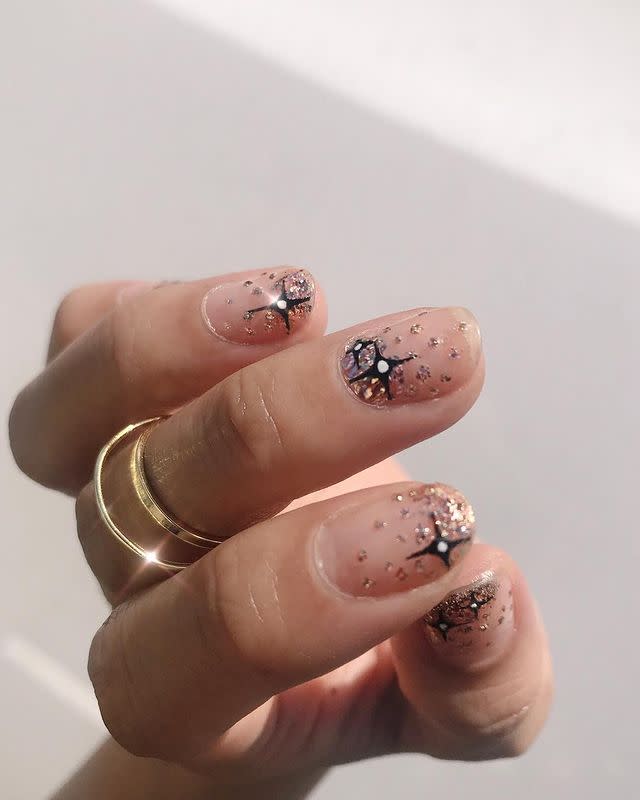 <p>Starry-night sky or glistening snowflakes? Doesn't matter—I'm into it, especially for the times when you don't want your nails to scream "nail art." Slick on a <a href="https://www.amazon.com/ILNP-Juliette-Holographic-Nail-Polish/dp/B018YOVQSI/ref=sr_1_3?keywords=glitter+nail+polish+rose+gold&qid=1575226439&sr=8-3&tag=syn-yahoo-20&ascsubtag=%5Bartid%7C10049.g.30065321%5Bsrc%7Cyahoo-us" rel="nofollow noopener" target="_blank" data-ylk="slk:rose-gold glitter polish;elm:context_link;itc:0;sec:content-canvas" class="link ">rose-gold glitter polish</a> (keeping the glitter concentrated near the tips alternated with the cuticle), then draw on crisscross black snowflakes.</p><p><a href="https://www.instagram.com/p/Br-gcffH2QA/" rel="nofollow noopener" target="_blank" data-ylk="slk:See the original post on Instagram;elm:context_link;itc:0;sec:content-canvas" class="link ">See the original post on Instagram</a></p>