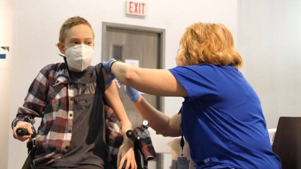 Riley Oldford, 16, gets the COVID-19 Pfizer-BioNTech vaccine on Thursday. Janie Neudorf, right, is the nurse who administered it. She said Riley is 'making history.'  (Mario De Ciccio/Radio-Canada - image credit)