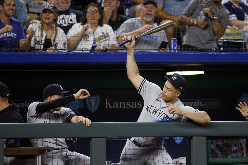 New York Yankees' Giancarlo Stanton, right, catches in the dugout a bat the slipped out of the hands of Kansas City Royals batter Matt Duffy during the seventh inning of a baseball game in Kansas City, Mo., Friday, Sept. 29, 2023. (AP Photo/Colin E. Braley)