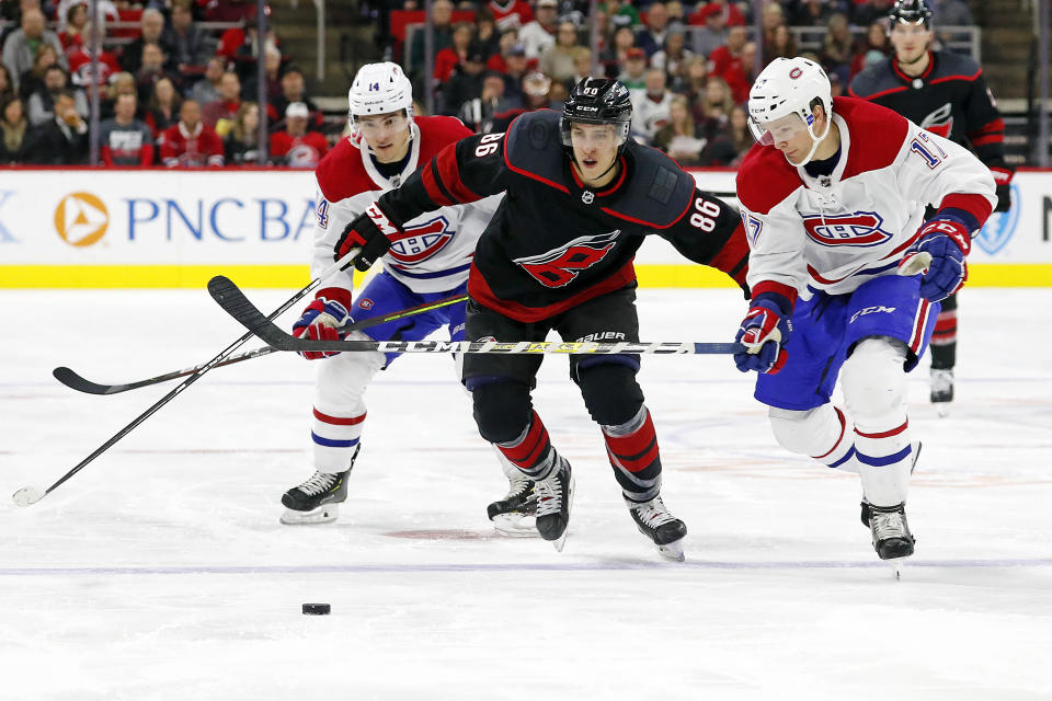 Carolina Hurricanes' Teuvo Teravainen (86), of Finland, battles between Montreal Canadiens' Nick Suzuki (14) and Brett Kulak (17) during the second period of an NHL hockey game in Raleigh, N.C., Tuesday, Dec. 31, 2019. (AP Photo/Karl B DeBlaker)