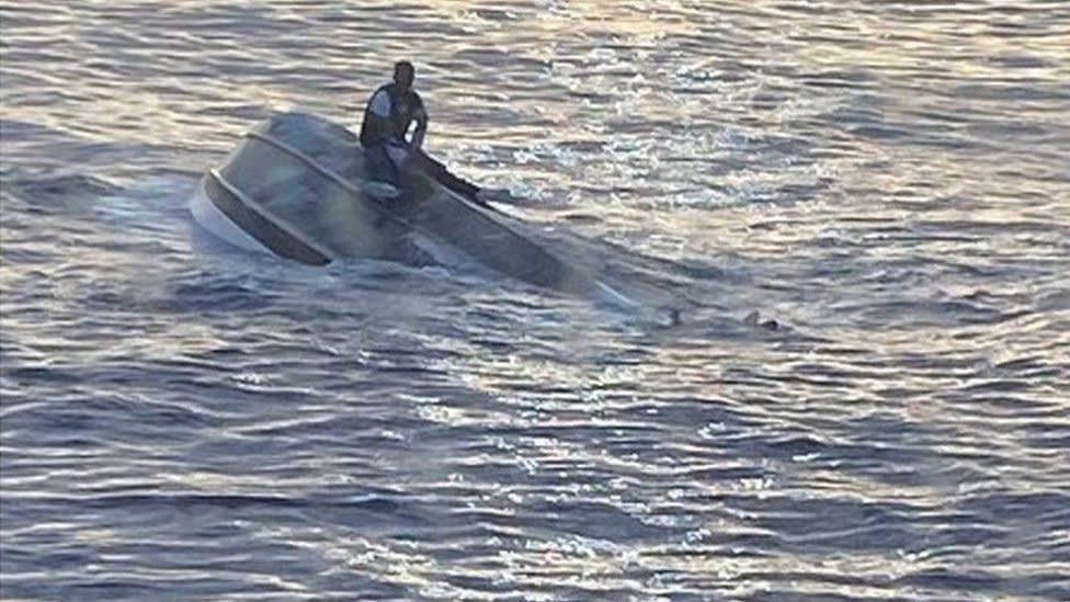 El sobreviviente montado encima del casco del barco.