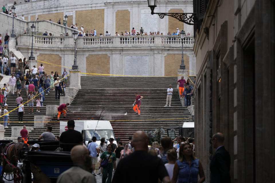 Rome municipality workers clean the Spanish Steps after activists dumped red paint over them protesting against violence on women, in Rome, Wednesday, June 26, 2024. (AP Photo/Andrew Medichini)
