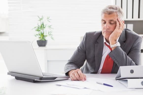 Man in business suit falling asleep at his desk