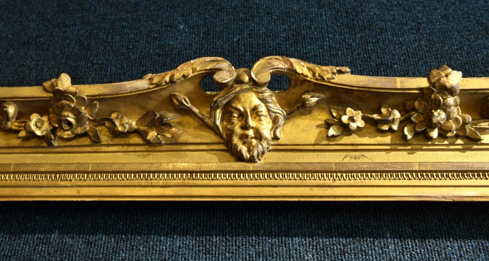 This frame from the 18th century features different faces carved on each side.