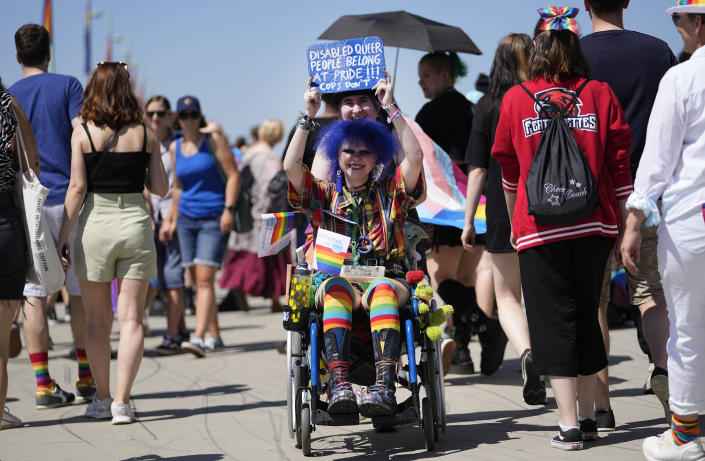 A participant of the Cologne Pride rally is pictured in a wheel chair in Cologne, Germany, Sunday, July 3, 2022. This year's Christopher Street Day (CSD) Gay Parade with thousands of demonstrators for LGBTQ rights is the first after the coronavirus pandemic to be followed by hundreds of thousands of spectators in the streets of Cologne. (AP Photo/Martin Meissner)