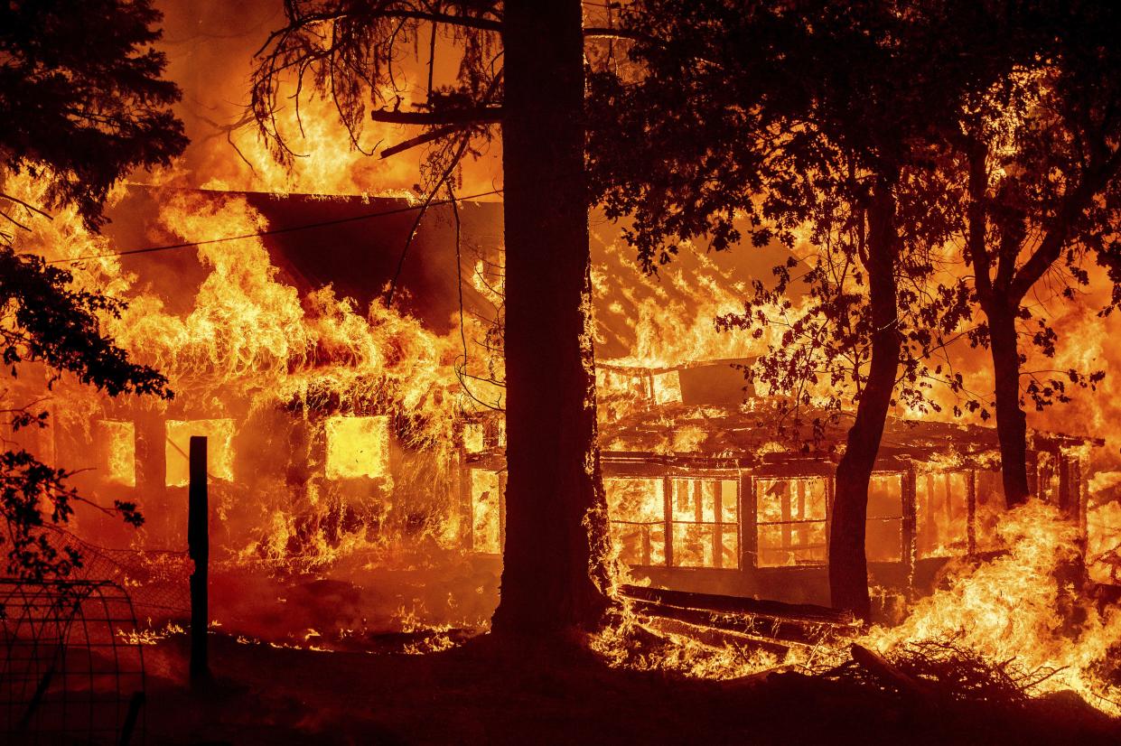 Flames from the Dixie Fire consume a home in the Indian Falls community of Plumas County, Calif. on Saturday, July 24, 2021. The fire destroyed multiple residences as it tore through the area.