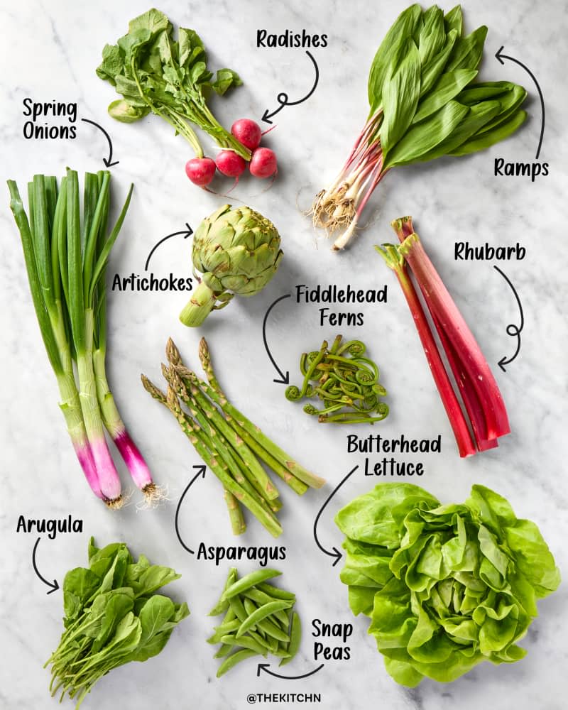 An assortment of 10 spring vegetables on a marble surface