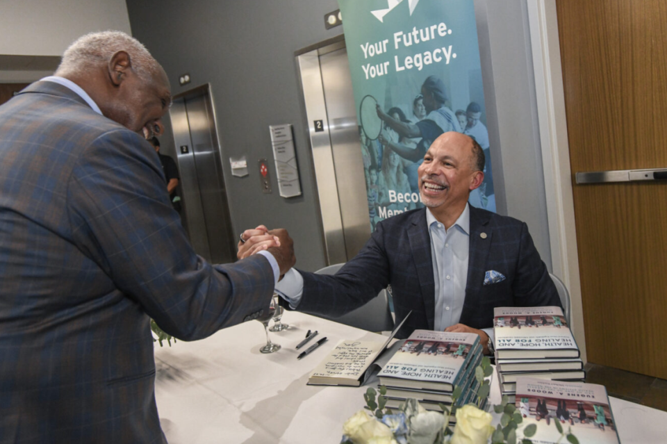 Gene Woods shakes hands with Harvey Gantt during an event celebrating the launch of Woods’ book this past November at the Harvey B. Gantt Center for African-American Arts in Charlotte.