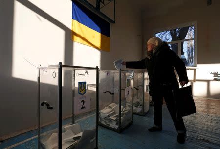 A woman casts a ballot during a parliamentary election at a school gym in the village of Semyonovka near Slaviansk, eastern Ukraine, October 26, 2014. REUTERS/Vasily Fedosenko