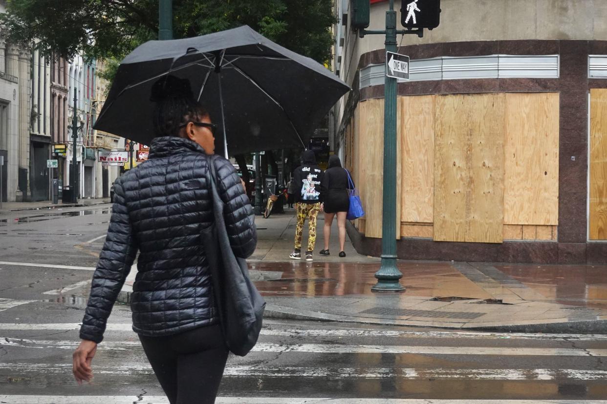 People walk in the French Quarter prior to the arrival of Hurricane Ida on Aug. 29, 2021, in New Orleans, Louisiana. The neighborhood is mostly quiet as residents of New Orleans continue to prepare, while the outer bands of Hurricane Ida begin to cut across the city. Ida is expected to make landfall as a category 4 storm later today.