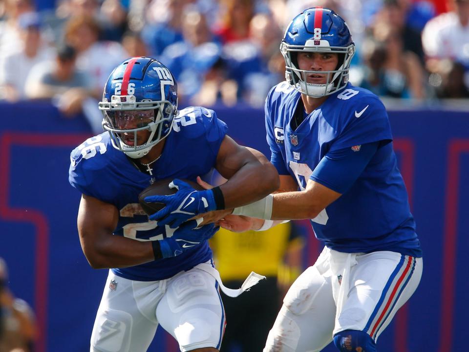 Daniel Jones hands the ball off to Saquon Barkley during a game against the Carolina Panthers.