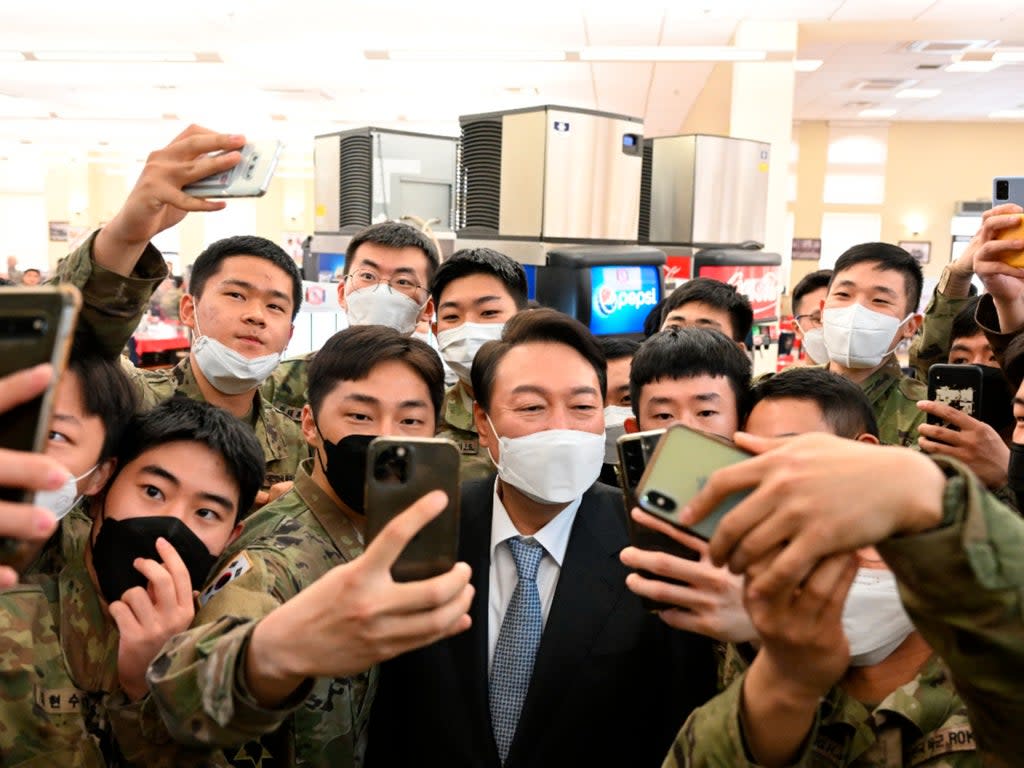South Korean president-elect Yoon Suk Yeol, centre, poses for selfies with soldiers  (AP)