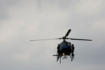 Police officers, members of a team known as "Condores", stand by the door of the helicopters during a patrol of the city, part of a new strategy to combat the crime in Mexico City, Mexico August 3, 2018. Picture taken August 3, 2018. REUTERS/Carlos Jasso