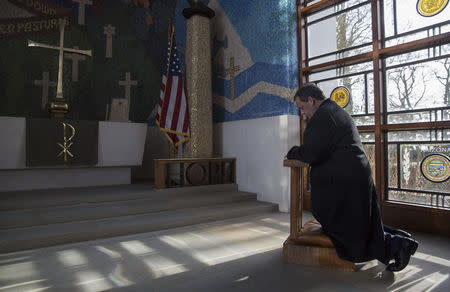 New Jersey Governor Chris Christie prays in a chapel during his visit to the American Cemetery in Cambridge, eastern England February 2, 2015. REUTERS/Neil Hall