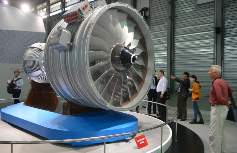 Visitors look at a full-size model of an aircraft jet engine made by China Aviation Industry Corporation (AVIC), at the China International Industry Fair in Shanghai, in 2013