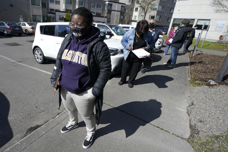 Jazlyn Collins, an elementary substitute teacher, waits in line to get the first dose of the Moderna COVID-19 vaccine, Monday, March 15, 2021, at a Seattle Indian Health Board clinic in Seattle. The SIHB began vaccinating front line staff from Seattle Public Schools Monday, including substitute teachers, custodians, nutrition services staff, special education teachers, and instructional aides, after determining they had enough doses of the vaccine to share with school workers. (AP Photo/Ted S. Warren)