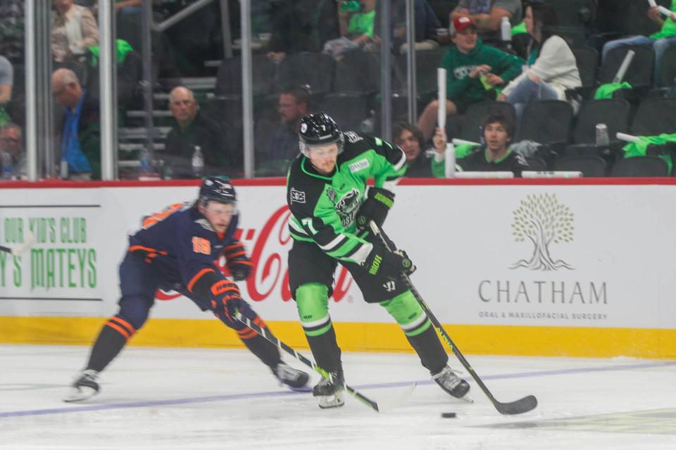 Savannah Ghost Pirates defenseman Brian Estes moves the puck as Greenville's Carter Souch attempts to block it away during the home opener at Enmarket Arena.