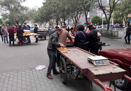 Vendors undersell fruits at an open market near the site of a blast in Urumqi, Xinjiang Uyghur Autonomous Region May 22, 2014. REUTERS/CNSphoto