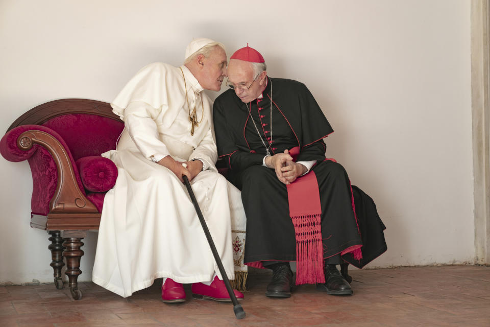 This image released by Netflix shows Jonathan Pryce as Cardinal Bergoglio, right, and Anthony Hopkins as Pope Benedict in a scene from "The Two Popes." (Peter Mountain/Netflix via AP)