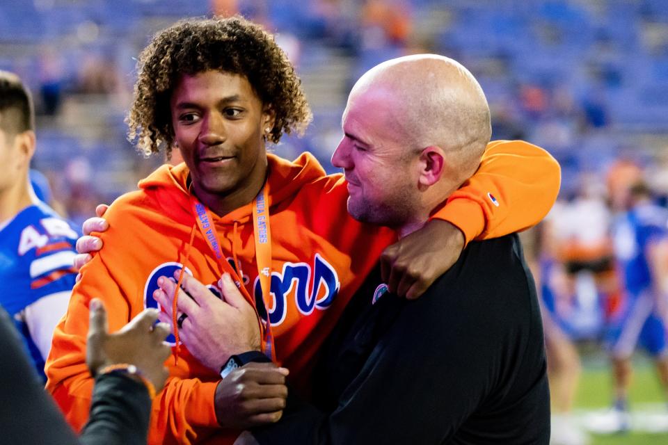 Jaden Rashada (L), a 4-star quarterback recruit from California who recently flipped his commitment from Miami to Florida, gets a hug from Gators' offensive coordinator Rob Sale (R) after UF's victory last week over South Carolina.