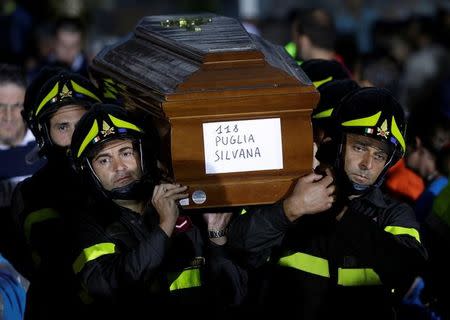 Firefighters carry a coffin at the end of funeral service for victims of the earthquake that levelled the town in Amatrice, central Italy, August 30, 2016. REUTERS/Max Rossi