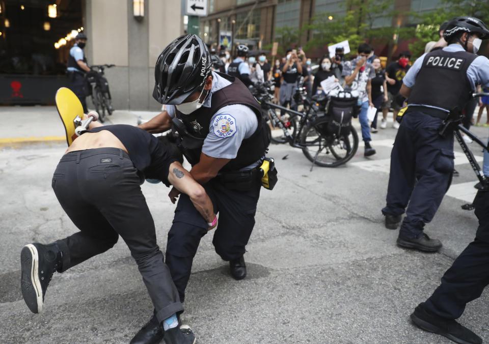 An officer takes down a protester after breaking through a police barrier during a march to bring attention to the death of George Floyd in the Loop Friday, May 29, 2020, in Chicago. Floyd died after being restrained by Minneapolis police officers on Memorial Day. (John J. Kim/Chicago Tribune via AP)