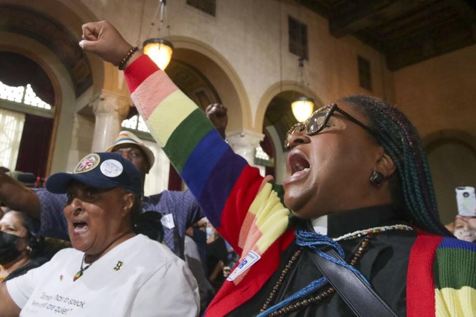 Pastor Thembekila Coleman-Smart and others raise their hands and voices at a council meeting