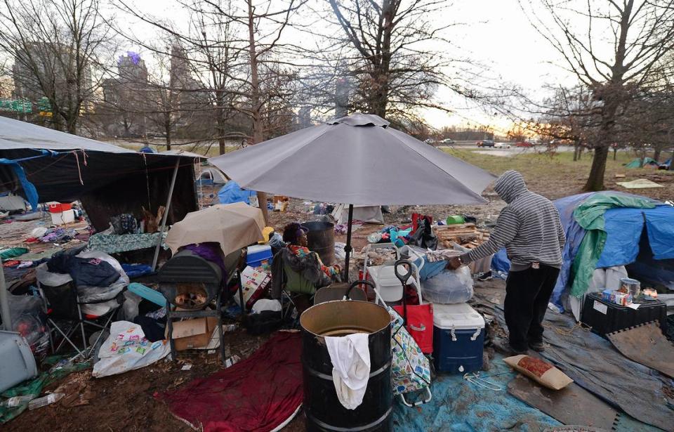 A woman, left, takes a break from moving her personal belongings as a companion, right, moves a few items to be taken from the homeless encampment near Graham Street in Charlotte, NC on Friday, February 19, 2021. Residents of tent encampment were required to vacate the area after health risks from rodent infestation were found in the area.