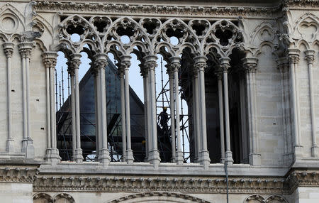 A man works at Notre Dame cathedral, in Paris, France April 18, 2019. Michel Euler/Pool via Reuters